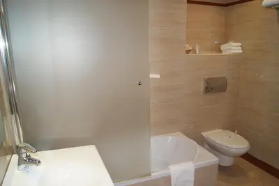 a bathroom with a toilet and a tub and a sink at Hostal Moreno in Silla