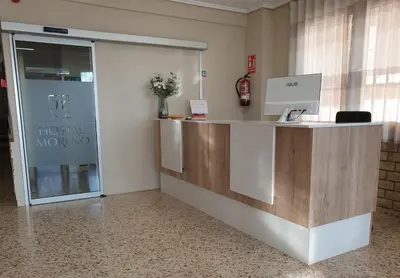 an office with a reception desk and a glass door at Hostal Moreno in Silla