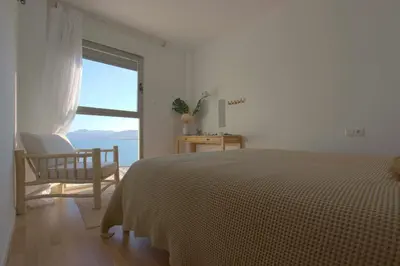 a bedroom with a bed and a chair and a window at Can Lou-Casa con Caracter en Cullera in Faro de Cullera