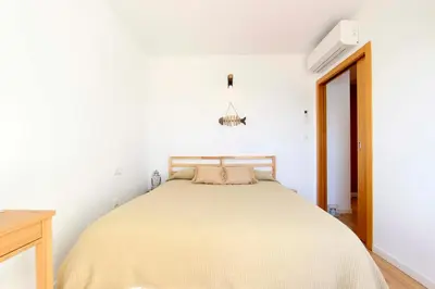 a bed in a white room with a bedspread on it at Can Lou-Casa con Caracter en Cullera in Faro de Cullera