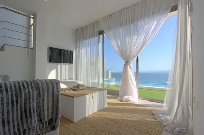 a living room with a large window with a view of the ocean at Can Lou-Casa con Caracter en Cullera in Faro de Cullera