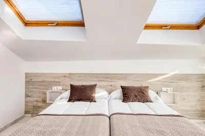a bedroom with two beds and two windows at Palau de Palomar - PalomarGroup in Valencia