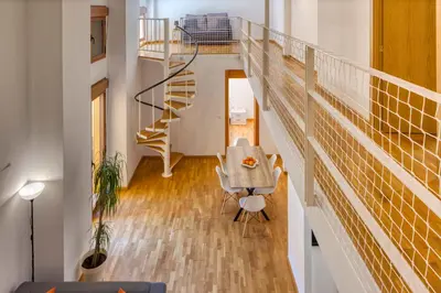 a room with a staircase and a table and chairs at Palau de Palomar - PalomarGroup in Valencia