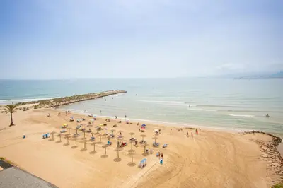 a group of people on a beach near the ocean at Hotel Sicania in Cullera