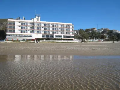 a building on the beach next to a beach at Hotel Sicania in Cullera