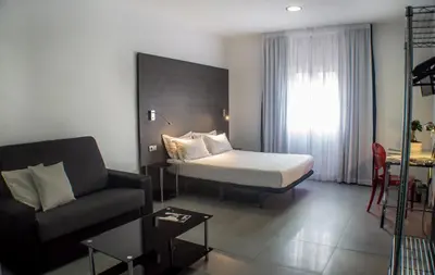 a hotel room with a bed and a couch and a room at Quart Youth Hostel & Apartments in Valencia