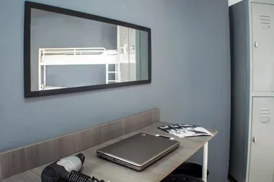 a mirror on a wall above a desk with a laptop at Quart Youth Hostel & Apartments in Valencia