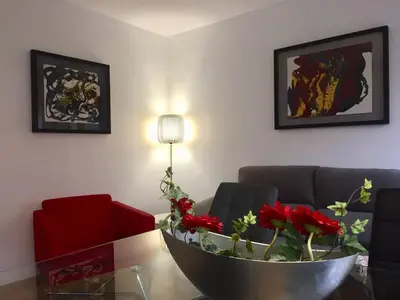 a living room with a couch and a table with red flowers at Apartamento en Universidad y cerca de la playa in Valencia