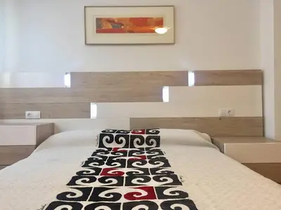 a bedroom with a bed with a black and white blanket at Apartamento en Universidad y cerca de la playa in Valencia