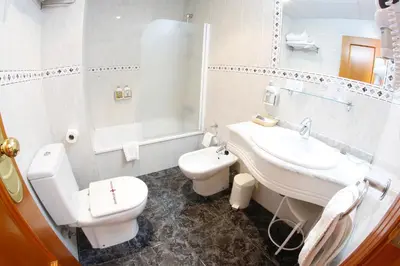 a white bathroom with a sink and a toilet at Maria de Luna in Segorbe