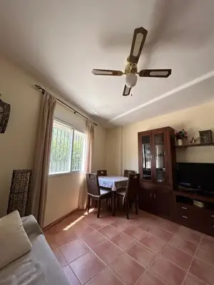 a living room with a table and a ceiling fan at Apartamento Casa Rafa in Navajas
