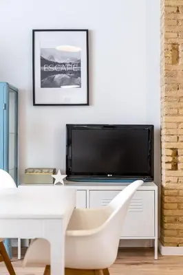 a living room with a white table and a tv at ANELSA Apmts DESCUBRE VALENCIA Y SU PLAYA in Valencia