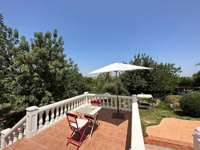 a patio with an umbrella and a table and chairs at CASA MARTINEZ MONTROY à 3 kms de MONTSERRAT VALENCIA in Montroy
