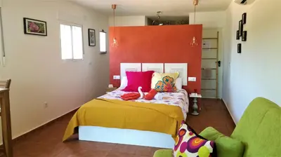 a bedroom with a bed with colorful pillows at CASA MARTINEZ MONTROY à 3 kms de MONTSERRAT VALENCIA in Montroy