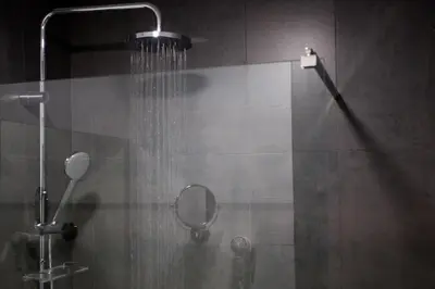 a shower with a shower head and a mirror at Hotel Malcom and Barret in Valencia
