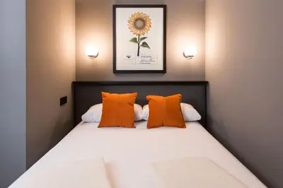 a bedroom with a bed with orange pillows at Hotel Malcom and Barret in Valencia