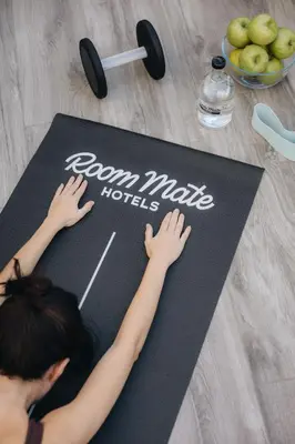 a girl laying on a yoga mat with the words camp make huts at Room Mate Cosmo - City Centre, Valencia in Valencia