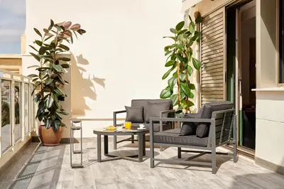 a patio with two chairs and a table on a balcony at Room Mate Cosmo - City Centre, Valencia in Valencia