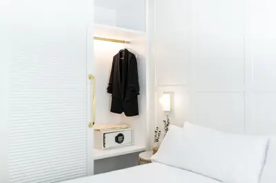 a bedroom with a bed and a black jacket hanging on a door at Room Mate Cosmo - City Centre, Valencia in Valencia