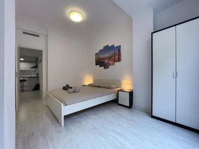 a white bedroom with a bed and a painting on the wall at Valencia Apartamento Estilo italiano in Valencia