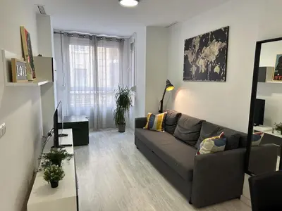 a living room with a gray couch and a mirror at Valencia Apartamento Estilo italiano in Valencia