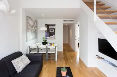a living room with a black couch and a table at Mon Suites Catedral in Valencia