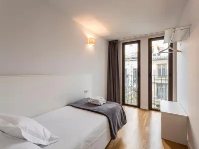 a bedroom with a bed and a large window at Mon Suites Catedral in Valencia