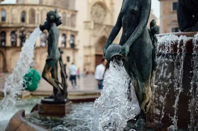 a water fountain with two statues in a city at Mon Suites Catedral in Valencia
