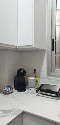a kitchen counter with a coffee cup and a microwave at Habitacion en casa de familia 