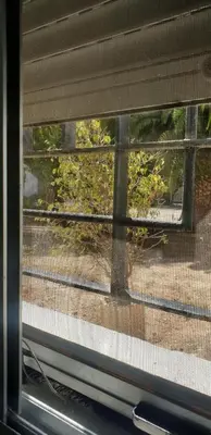 a window with a view of a street behind it at Habitacion en casa de familia 