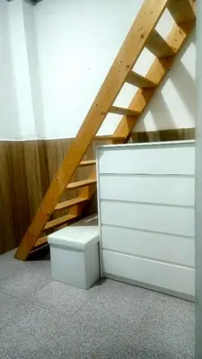 a attic room with a stairs and a white drawer at Habitacion en casa de familia 