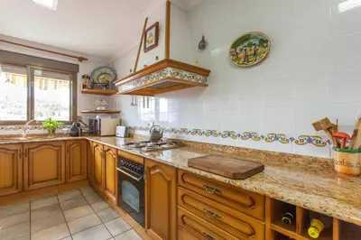 a kitchen with wooden cabinets and a stove top oven at Casa Rural Garza in Pedralba