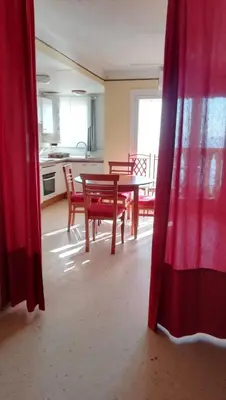 a room with a table and chairs and a kitchen at IDEALLY located on BEACH in Port Saplaya