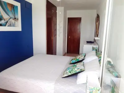 a bedroom with a large bed with a mirror at IDEALLY located on BEACH in Port Saplaya