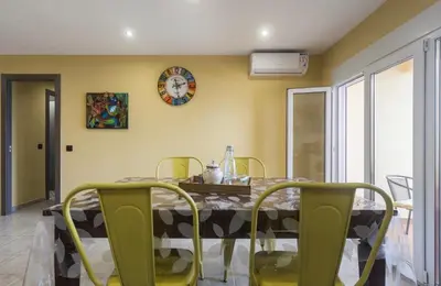 a dining room with a table and chairs and a clock at Sea view Port Saplaya Apartments,2 in Port Saplaya