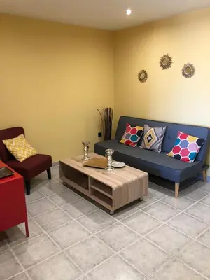 a living room with a blue couch and a table at Sea view Port Saplaya Apartments,2 in Port Saplaya
