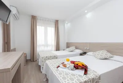 a hotel room with two beds and a tray of food at Hotel Olympia Ronda II in El Puig