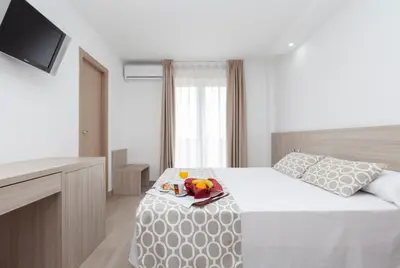 a bedroom with a bed with a tray of toys on it at Hotel Olympia Ronda II in El Puig