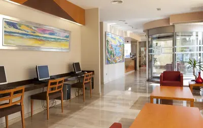 a waiting room at a hospital with tables and chairs at Hotel Olympia Ronda II in El Puig