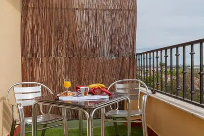 a table with a plate of food on a balcony at Hotel Olympia Ronda II in El Puig