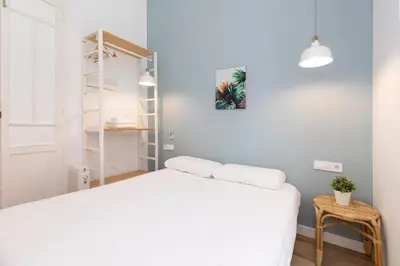 a bedroom with a white bed and a shelf at Cozy apartment Valencia city center! in Valencia