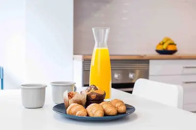 a plate of pastries on a table with a bottle of orange juice at Cozy apartment Valencia city center! in Valencia