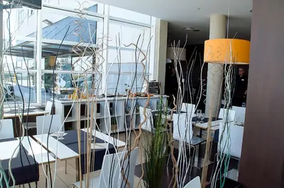 a room with tables and chairs and a large window at Hotel AS Torrent in Torrent