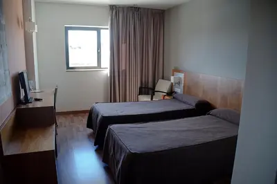a hotel room with two beds and a television at Hotel AS Torrent in Torrent