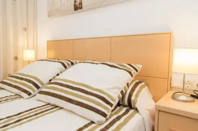 a bedroom with a bed with two pillows on it at Los Olivos Apartment Cullera in Cullera