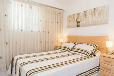 a bedroom with a large bed with two pillows at Los Olivos Apartment Cullera in Cullera