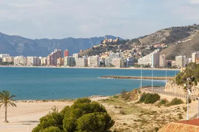 a beach in front of a city with buildings at Los Olivos Apartment Cullera in Cullera