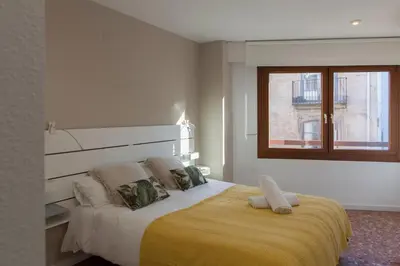 a bedroom with a large bed with a yellow blanket at FLORIT FLATS - Apartment Torres de Quart I in Valencia