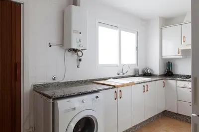 a white kitchen with a washing machine in it at FLORIT FLATS - Apartment Torres de Quart I in Valencia