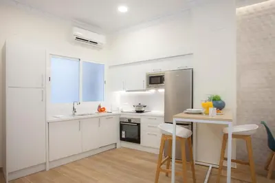 a kitchen with white cabinets and a table and chairs at SingularStays Seu Catedral in Valencia